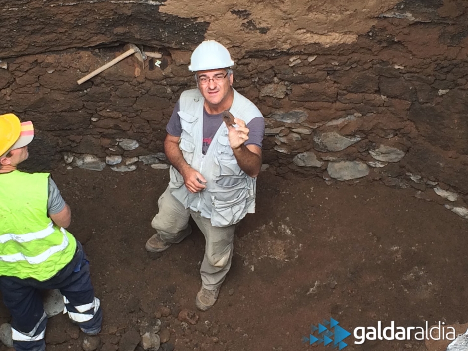 El arqueólogo encargado enseña restos de un asa de una vasija prehispánica.